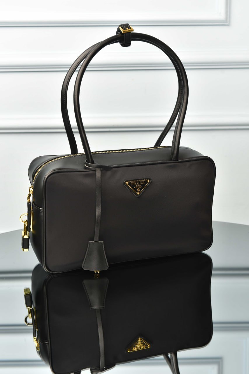 5881783817692367344 Re-Nylon and Leather Medium Top-Handle Bag with Padlock - Image 1